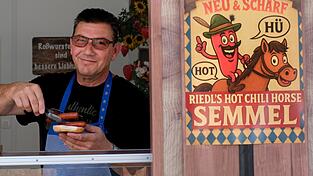 Pferdemetzger Josef Riedl und seine neue Wurst am Gäubodenvolksfest. Die Hot-Chili-Horse-Semmel wurde extra kreiert.