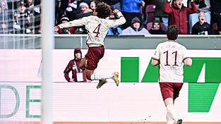 Han-Noah Massengo hebt nach seinem 1:0 jubelnd ab - zum Sieg reichte sein Kopfballtor für den FC Augsburg aber nicht. Han-Noah Massengo hebt nach seinem 1:0 jubelnd ab - zum Sieg reichte sein Kopfballtor für den FC Augsburg aber nicht.