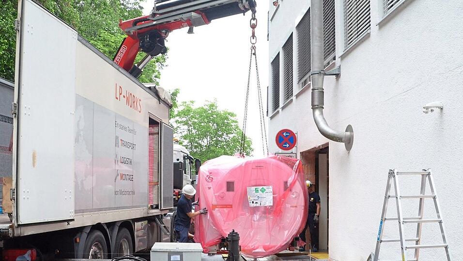 Der neue Magnetresonanztomograph wird zur ge&ouml;ffneten Wand gehoben und in die Klinik eingebracht.