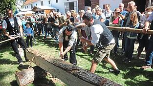 Die Zimmerer führten die Kunst des Balkenhauens aus einem Baumstamm vor.
