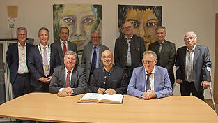 Der Eintrag ins Goldene Buch mit Django As&uuml;l (sitzend, Mitte), Staatsminister Christian Bernreiter (sitzend, l.) und Hengersbergs Altb&uuml;rgermeister Christian Mayer (sitzend, r.). Landrat Bernd Sibler und B&uuml;rgermeister Mathias Berger (v. l.) mit den weiteren Geehrten und Verabschiedeten.