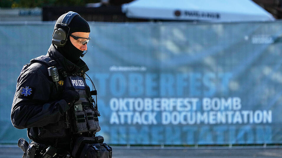 Ein Polizist geht über das nach einer Bombendrohung geschlossene Oktoberfest-Gelände. Ein Polizist geht über das nach einer Bombendrohung geschlossene Oktoberfest-Gelände.