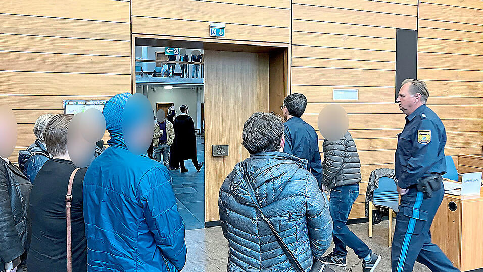 Die Familie des Angeklagten steht Spalier, als er nach der Verhandlung abgeführt wird. Die Familie des Angeklagten steht Spalier, als er nach der Verhandlung abgeführt wird.