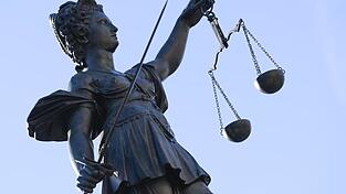 Eine Statue der Justitia steht unter freiem Himmel.