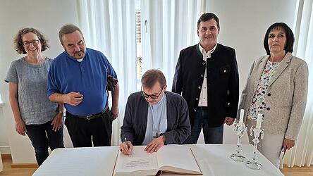 Bischof Tom&aacute;&scaron; Holub aus Pilsen tr&auml;gt sich ins Goldene Buch der Marktgemeinde Neukirchen b. Hl. Blut ein.