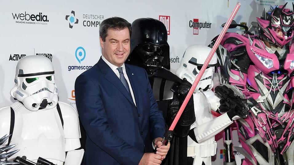 Markus Söder hält ein Laserschwert.