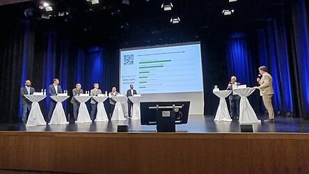 Herren auf der B&uuml;hne: Die sechs landratskandidaten und Richard Brunner (IHK) sowie Moderator Martin Lindner.