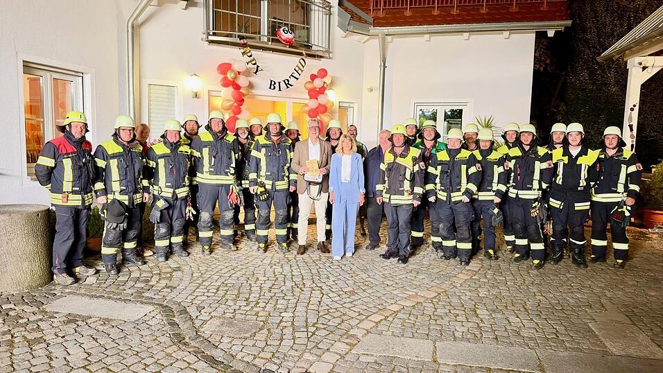 Jubilar Ulrich Fischer zusammen mit seiner Frau Christa und seinen Kameraden der Stadtfeuerwehr.