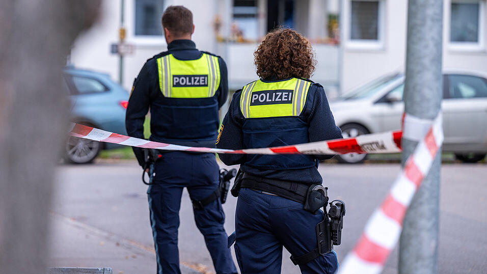 Polizeibeamte stehen an der Absperrung am Tatort. 