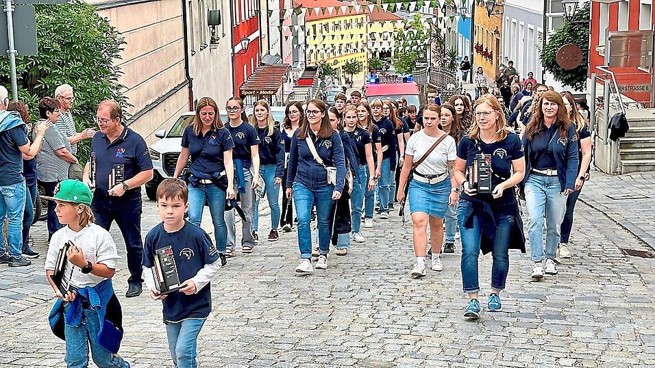 Zwei Kinder und die beiden Ausbilder Caroline Rank und Hermann Dirscherl präsentierten beim Marsch zum Stadtplatz die Trophäen.