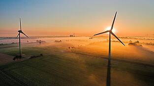 Die aufgehende Sonne taucht &uuml;ber Feldern und Windr&auml;dern den Nebel in warmes Licht. Nicht alle sind der Windkraft aber wohlgesonnen. Vor allem dann nicht, wenn das Windrad in n&auml;chster N&auml;he steht.