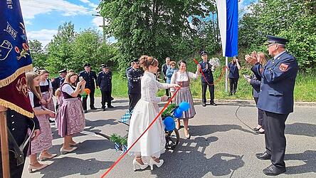 Mit dem Durchtrennen des roten Patenbandes durch Festmutter Manuela Blend und Festbraut Simone Kulzer wird die Patenschaft besiegelt.