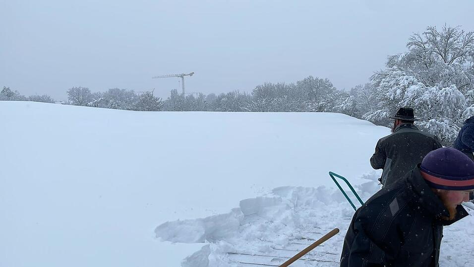Die Firma 'Leutner und Gruber GmbH' ist schon den ganzen Tag auf dem Dach des Straubinger Eisstadions zugange, um es von rund 40 Zentimeter hoch liegendem Neuschnee zu befreien.