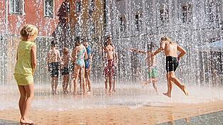 Ein Wasserspiel wie hier in Regensburg sorgt an heißen Tagen verlässlich für Abkühlung. Doch das Thema Hitze spielt auch bei stadtplanerischen Aspekten zunehmend eine Rolle. Derartige Maßnahmen sind zwar weniger sichtbar, aber oft genauso wirksam.