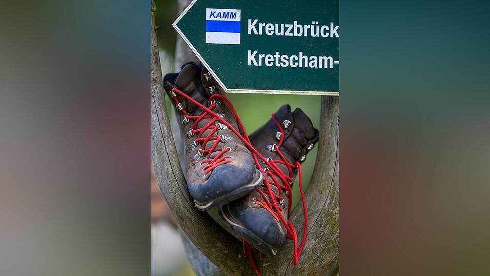 Wanderschuhe stehen in einem Wegweiser am Fu&szlig; des Fichtelbergs.