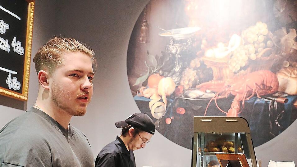 Wirklich mond&auml;n geht es bei 'Karls Leberkas' nur an der Wand zu: Unter dem Bild eines riesigen Hummers bringen Ferdi (vorne) und Daniel die Leberkassemmel an den Kunden. Sie machen den Job schon seit eineinhalb Jahren - mittlerweile l&auml;uft die Arbeit v&ouml;llig automatisch.