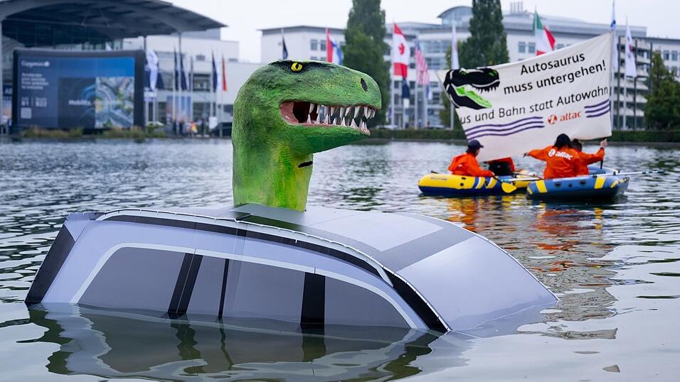 Schon vor der offiziellen Eröffnung protestierte Attac mit einem «Autosaurus» am Münchner Messegelände. Schon vor der offiziellen Eröffnung protestierte Attac mit einem «Autosaurus» am Münchner Messegelände.