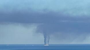 Rauch steigt von dem Schiff vor der griechischen Insel Korfu auf. Rauch steigt von dem Schiff vor der griechischen Insel Korfu auf.