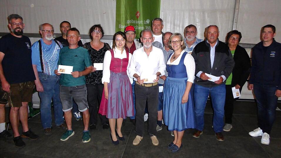 Festmutter Marie-Luise Skinner und Festbraut Franziska Fritsch gratulieren dem Sieger Manfred Ried, der sich gegen 355 weitere Teilnehmer beim Preisschafkopfturnier der Feuerwehr Wetterfeld durchsetzen konnte.