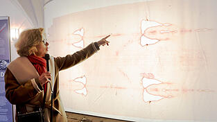 Kuratorin Sophie von Bechtolsheim mit dem Faksimile des Tuchs. Die großen Löcher stammen von einem Brand. Kuratorin Sophie von Bechtolsheim mit dem Faksimile des Tuchs. Die großen Löcher stammen von einem Brand.