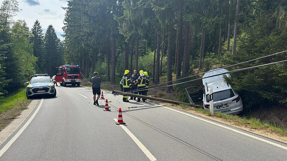 Durch den Unfall kippte der Telefonmast auf die Stra&szlig;e. Er musste von der Feuerwehr gekappt und die Leitung gesichert werden.