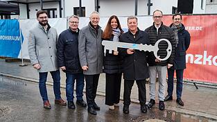 Die symbolische Schlüsselübergabe (v.l.): Alexander Hartl (stv. Geschäftsführer Penzkofer Bau), MdL Josef Zellmeier, OB Markus Pannermayr, Kristina Frank (Geschäftsführerin Baunova Bayern GmbH), Staatsminister Christian Bernreiter, MdL Martin Behringer und Fabian König (Geschäftsführer BayernHeim).