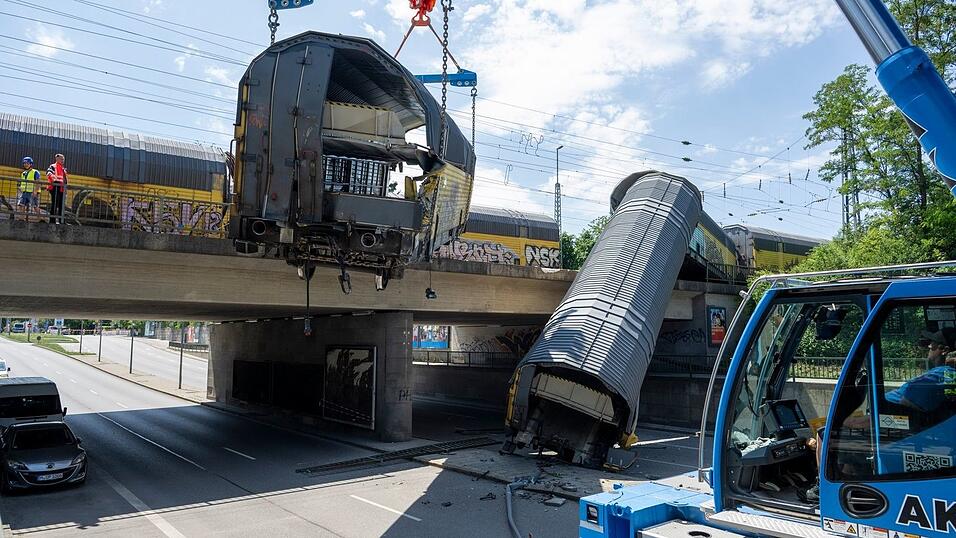 Zwei Waggons waren von einer Br&uuml;cke auf die darunter liegende Stra&szlig;e gekippt.