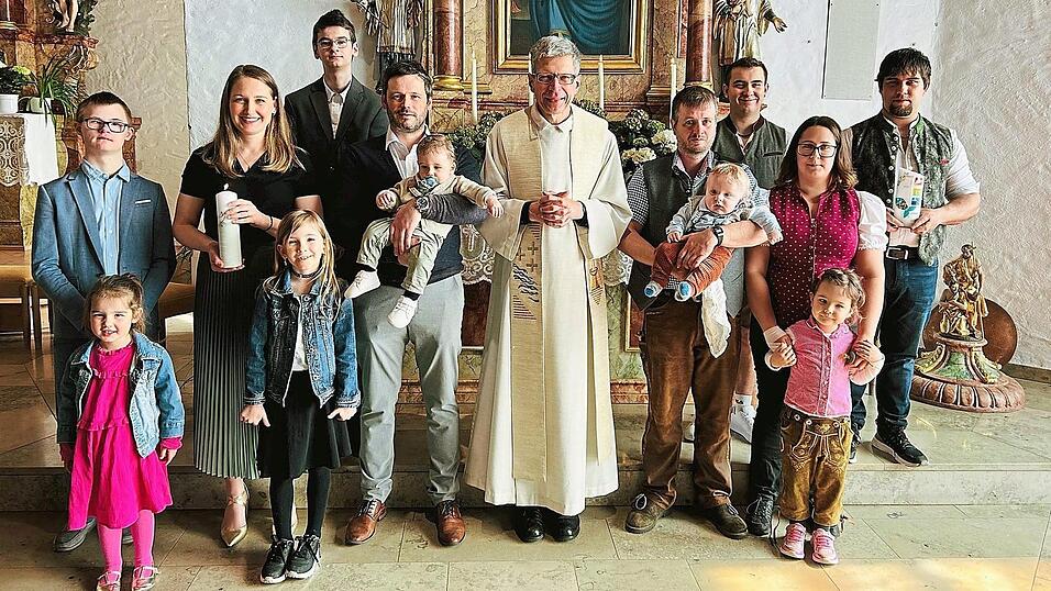 Die T&auml;uflinge Benedikt Schmuderer (links) und Ludwig Eckl mit ihren Eltern und Pfarrer Wutz, den Taufpaten, der kleinen Runa sowie ihren Schwestern Laura und Lisa.