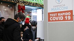 Menschen in Rom warten vor einer Apotheke auf einen Corona-Test. Menschen in Rom warten vor einer Apotheke auf einen Corona-Test.