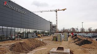 Die Materialfluss-Arena ist baulich bereits weit fortgeschritten, daneben entstehen noch der Eingangsbereich inklusive dem Bereich Markenerlebnis und das B&uuml;rogeb&auml;ude sowie weitere Parkpl&auml;tze.