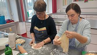 Pauline Gradewohl und Rosa Eberl bereiten eine traditionelle Mehlspeise, sogenannte Reinzelten mit Vanilliesauce zu.