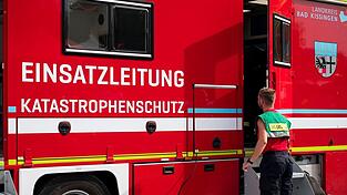Ein Feuerwehrmann steht vor dem Fahrzeug der Einsatzleitung des Katastrophenschutzes der Feuerwehr. Ein Feuerwehrmann steht vor dem Fahrzeug der Einsatzleitung des Katastrophenschutzes der Feuerwehr.