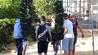 Einige Sch&uuml;ler der Klasse 10a tragen die Firstkrone, die beim Richtfest auf das neue Schulgeb&auml;ude gesetzt werden soll.