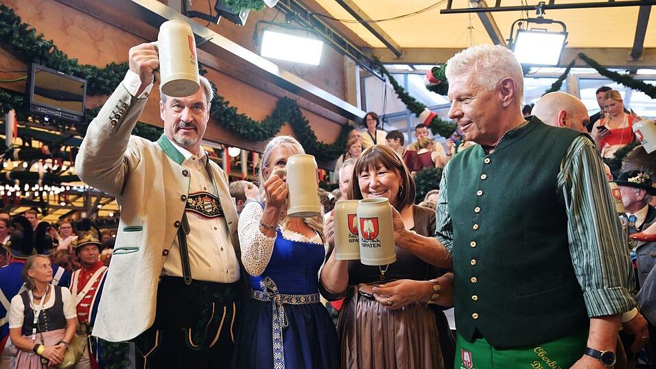 Bayerns Ministerpräsident Söder (l.) und Münchens OB Reiter (r.) stoßen mit ihren Ehefrauen auf eine friedliche Wiesn an. Bayerns Ministerpräsident Söder (l.) und Münchens OB Reiter (r.) stoßen mit ihren Ehefrauen auf eine friedliche Wiesn an.