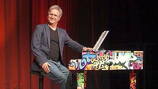 Chris Boettcher verwandelte den Konzertsaal der Musikschule in eine humorvolle Zeitmaschine.