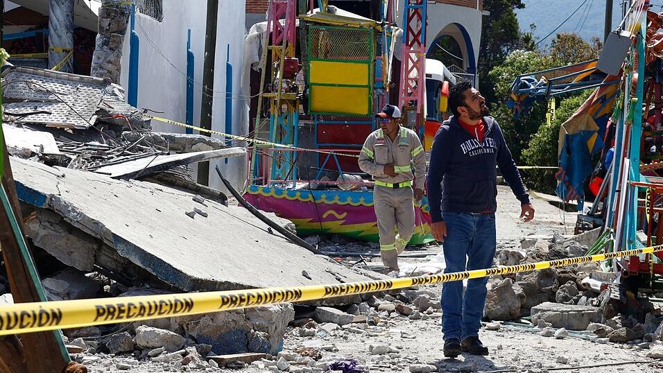 Feuerwehrleute untersuchten das durch eine Feuerwerksexplosion zerstörte Gebiet. Feuerwehrleute untersuchten das durch eine Feuerwerksexplosion zerstörte Gebiet.
