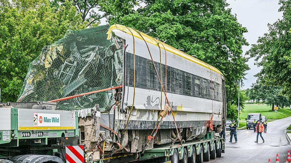 Ein verladener Zug Wagon steht an der Unfallstelle, an der ein Regionalzug entgleist ist. Ein Regionalexpress war am Sonntagabend (27.07.2025) in Riedlingen nach bisherigen Erkenntnissen infolge eines Hangrutsches entgleist.