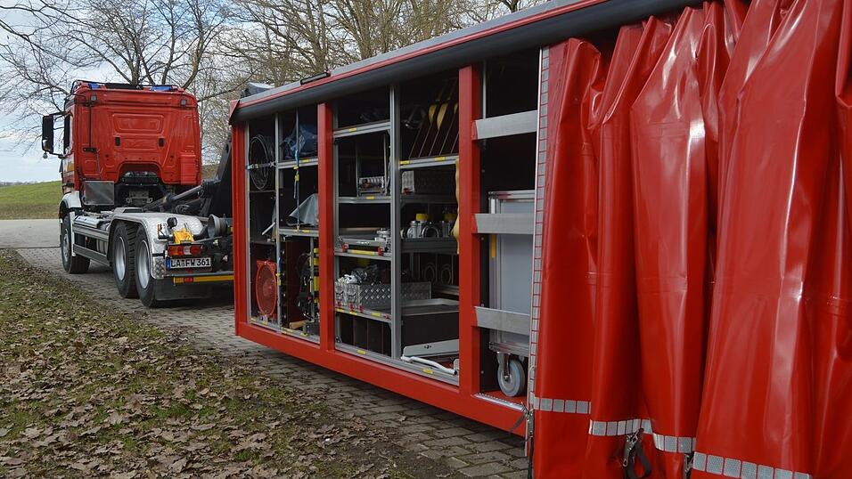 Das Wechsellader-Fahrzeug transportiert den Rollcontainer (rechts), die Lademulde und den neuen wasserdichten Container. Das Wechsellader-Fahrzeug transportiert den Rollcontainer (rechts), die Lademulde und den neuen wasserdichten Container.
