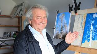 Egon Humbs präsentiert das Gemälde, an dem er aktuell arbeitet.