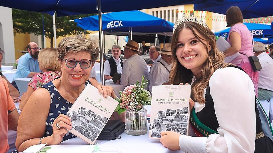 Vizebürgermeisterin Hannelore Langwieser und die Hallertauer Bierkönigin Karolin Ruhfaß blättern in der Stadtchronik.