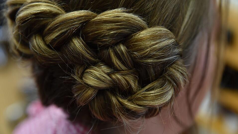 Der Zopf wird nun zu einem Dutt zusammengerollt und mit Haarklammern fixiert. Der Zopf wird nun zu einem Dutt zusammengerollt und mit Haarklammern fixiert.