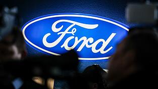 Ein Firmenschild des Autobauers Ford bei einer Betriebsversammlung Ende 2024: Das Unternehmen macht schwierige Zeiten durch.