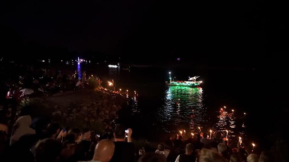 Bunt beleuchtete Boote fahren bei der Lampionfahrt über die Donau.