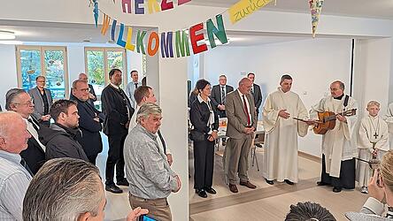 &bdquo;Herzlich willkommen zur&uuml;ck!&ldquo;, prangte es in bunten Lettern. Pfarrer Adolf Sch&ouml;ls (mit Gitarre) segnete nach einer kleinen Andacht in der Aula die sanierten und neu entstandenen R&auml;ume.