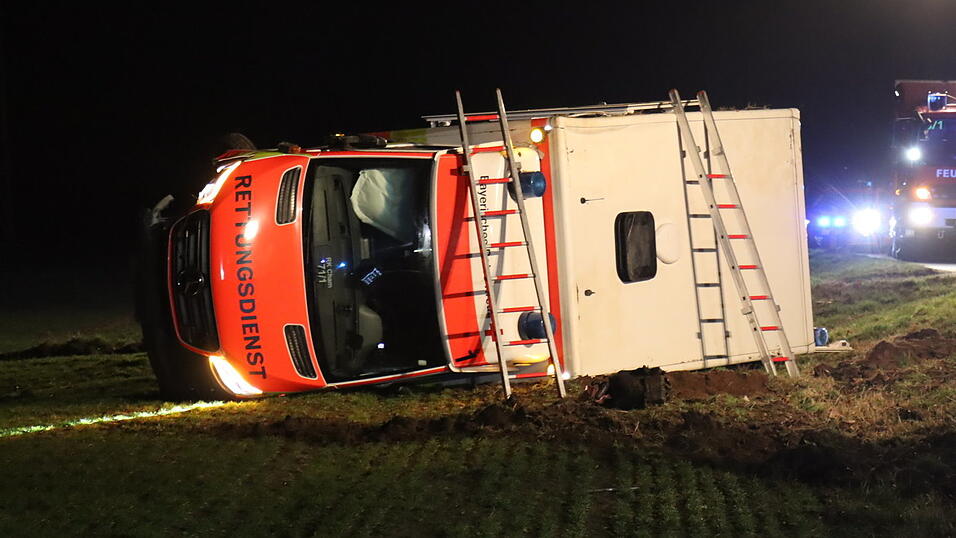 Der Rettungswagen kam nach der Kollision mit einem Auto in einem angrenzenden Feld auf der Fahrerseite zum Liegen.
