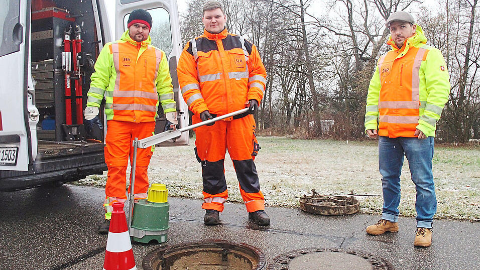 Die gr&uuml;ne K&ouml;derbox wird in den Abwasserschacht eingeklemmt. Im gelben Geh&auml;use befindet sich die Elektronik, die an ein Tablet meldet, wie viele Ratten die Box besucht haben. Die SER-Mitarbeiter Patrick Winterl, Lukas Karbacher und Josef Langhansl sind froh &uuml;ber die neue und umweltfreundliche Sch&auml;dlingsbek&auml;mpfung.