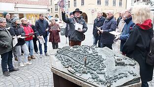 Ausgangspunkt der &bdquo;Bilderzeitreise&ldquo; mit Stefan Metzenauer (mit Hut) ist das Stadtmodell am L&auml;ndtor.