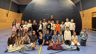 Beim Gruppenbild vor dem mobilen Planetarium wird dessen kuppelf&ouml;rmiger Aufbau deutlich, der entfernt einem Iglu-Zelt &auml;hnelt.