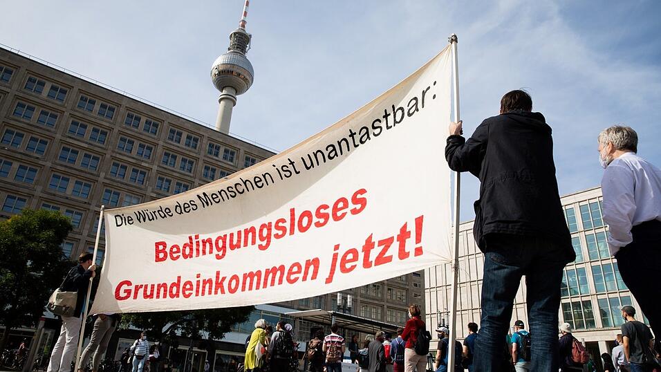'Bedingungsloses Grundeinkommen jetzt!' steht bei der Kundgebung einer Demonstration für ein bedingungsloses Grundeinkommen im Jahr 2020 auf dem Berliner Alexanderplatz auf einem Banner geschrieben. Die Langzeitstudie wurde jetzt abgeschlossen und zeigt: Menschen arbeiten nicht weniger. 'Bedingungsloses Grundeinkommen jetzt!' steht bei der Kundgebung einer Demonstration für ein bedingungsloses Grundeinkommen im Jahr 2020 auf dem Berliner Alexanderplatz auf einem Banner geschrieben. Die Langzeitstudie wurde jetzt abgeschlossen und zeigt: Menschen arbeiten nicht weniger.