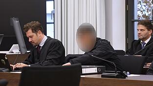Der Angeklagte sitzt zwischen seinen beiden Rechtsanw&auml;lten im Gerichtssaal.